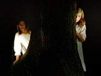 A mother and child hide behind a tree in the dark, in Purple Lipstick by Heather Haley